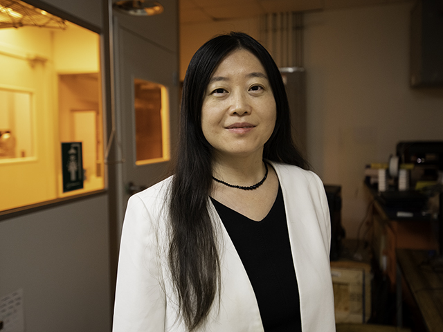 Emma Fan wearing white blazer in front of lab